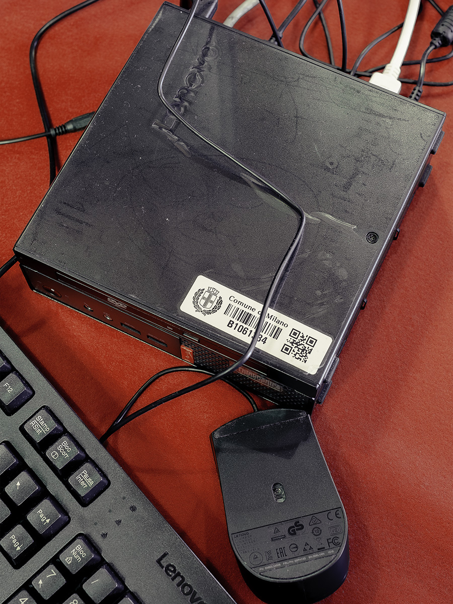 Un computer del comune di milano con una tastiera e un mouse, sopra uno sfondo rosso